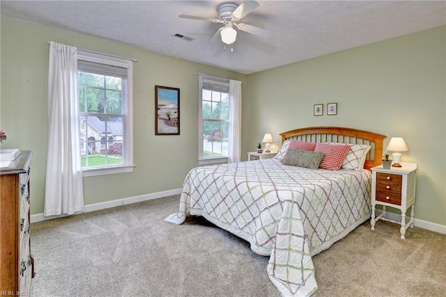 bedroom with carpet floors, baseboards, ceiling fan, and a textured ceiling