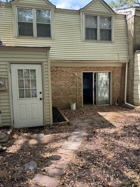 rear view of house featuring brick siding