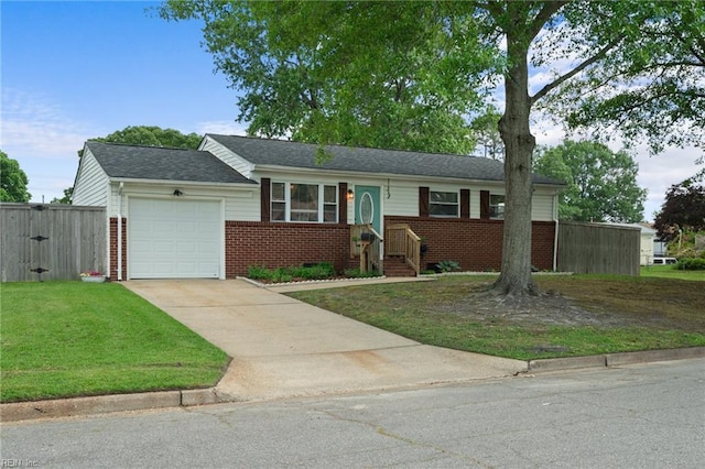 single story home featuring an attached garage, fence, a front yard, brick siding, and driveway