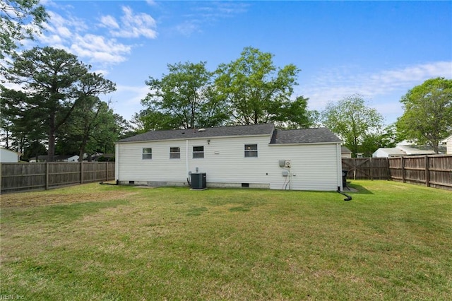back of house with central air condition unit, a fenced backyard, a yard, and crawl space