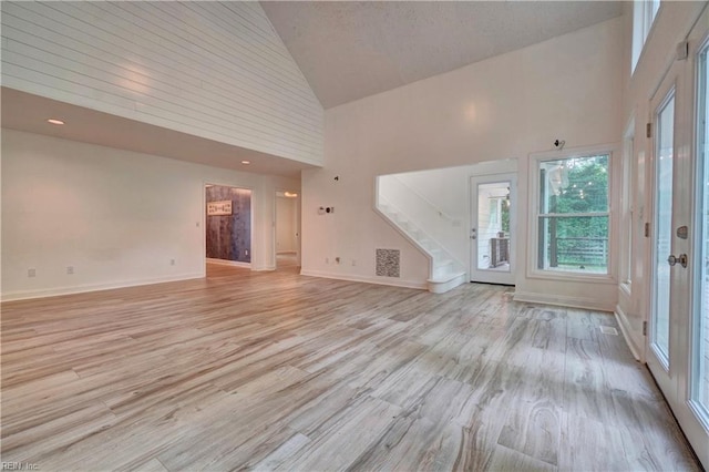 490 Poplar Lawn Rd, Surry, VA 23883 - unfurnished living room featuring stairway, light wood finished floors, high vaulted ceiling, and visible vents