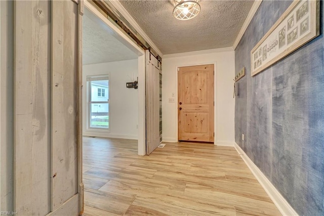 490 Poplar Lawn Rd, Surry, VA 23883 - corridor featuring a textured ceiling, ornamental molding, a barn door, light wood finished floors, and baseboards