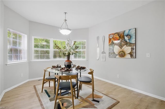 dining space with plenty of natural light, light wood-style floors, and baseboards