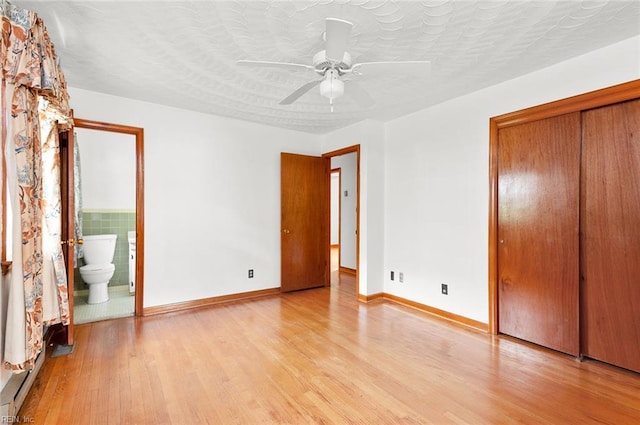 unfurnished bedroom featuring light wood-style flooring, a closet, baseboards, and a ceiling fan