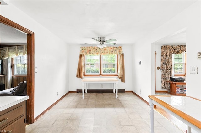 dining space with ceiling fan and baseboards