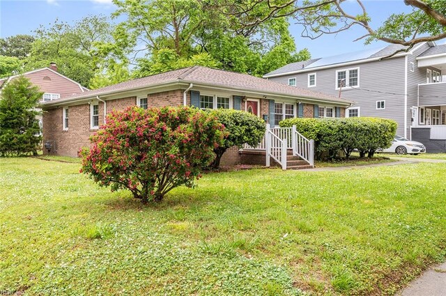 view of front of property featuring brick siding and a front yard