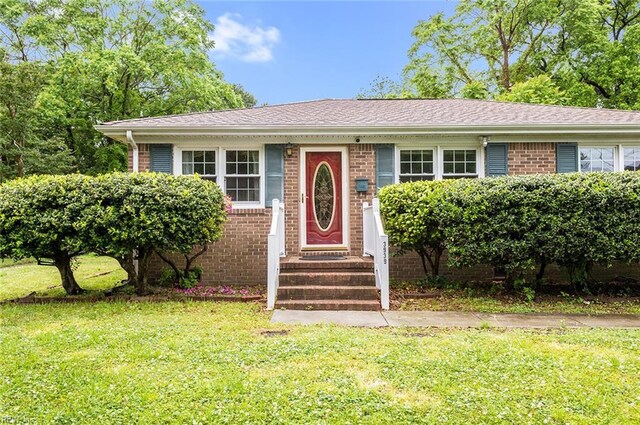 view of front of home featuring a front lawn, brick siding, and entry steps