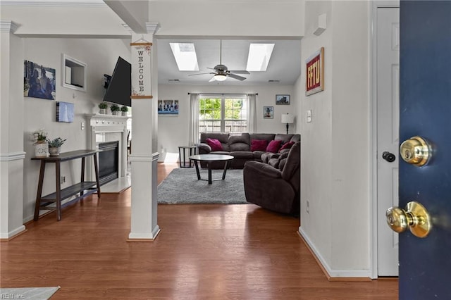 1409 Shady Tree Way, Chesapeake, VA 23323 - living area featuring a skylight, ceiling fan, wood finished floors, a fireplace with flush hearth, and baseboards