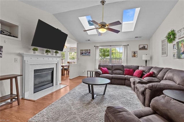 1409 Shady Tree Way, Chesapeake, VA 23323 - living room featuring a skylight, lofted ceiling, a ceiling fan, wood finished floors, and a premium fireplace