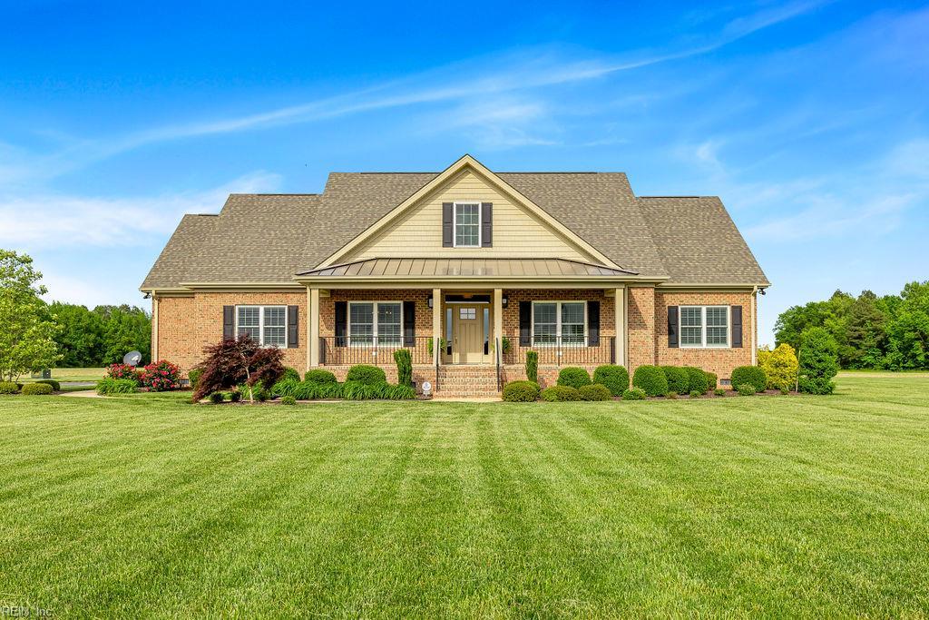 28487 Sunbeam Rd, Franklin, VA 23851 - traditional-style home with a porch, brick siding, a front yard, and a standing seam roof