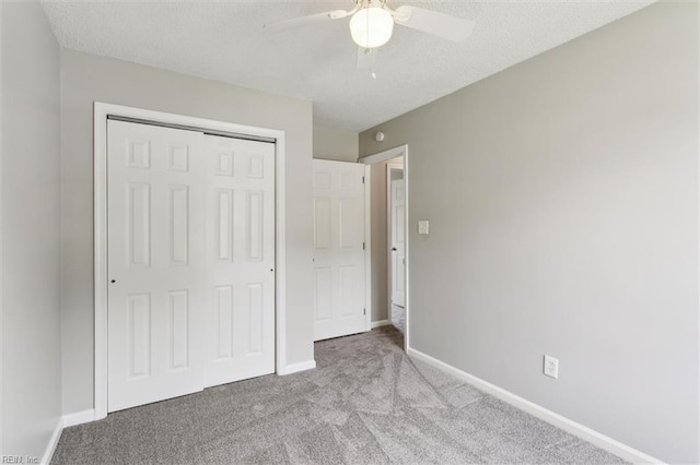 unfurnished bedroom with carpet floors, a closet, baseboards, ceiling fan, and a textured ceiling