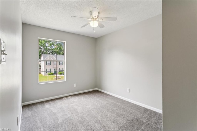 carpeted empty room with a ceiling fan, a textured ceiling, and baseboards