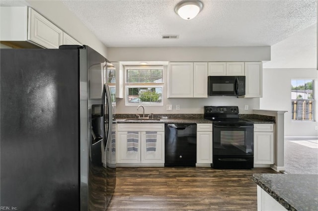 kitchen featuring black appliances, a sink, a textured ceiling, and white cabinets
