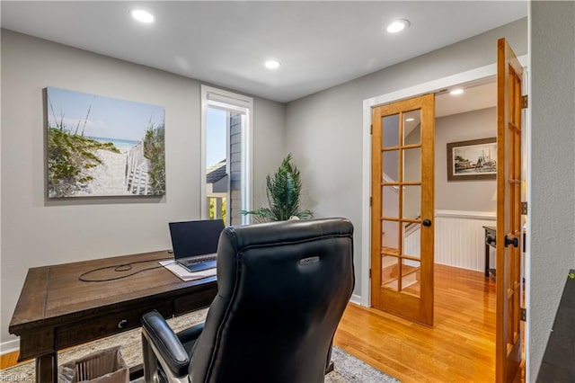 office space with a wainscoted wall, light wood-type flooring, french doors, and recessed lighting