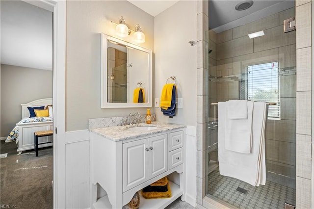 bathroom featuring a stall shower, vanity, and a wainscoted wall