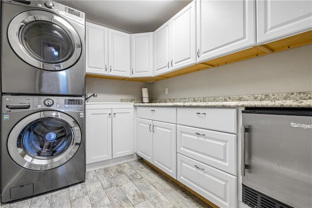laundry area featuring cabinet space and stacked washer / dryer