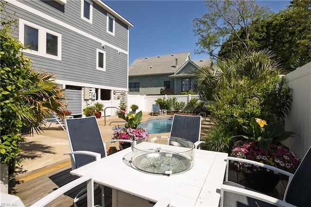 view of patio / terrace with outdoor dining area, a fenced in pool, and a fenced backyard