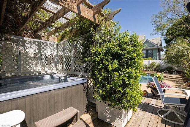 wooden deck featuring a hot tub, a pergola, fence, and an outdoor pool