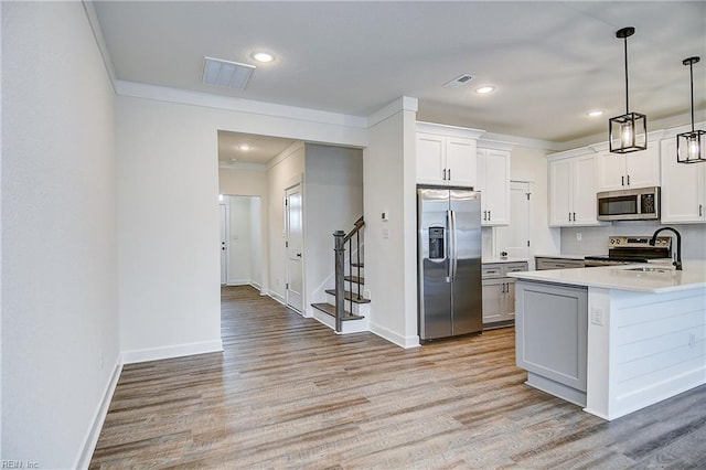 kitchen with a sink, light wood-type flooring, visible vents, and appliances with stainless steel finishes