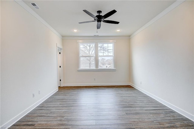 spare room with a ceiling fan, baseboards, visible vents, crown molding, and wood finished floors
