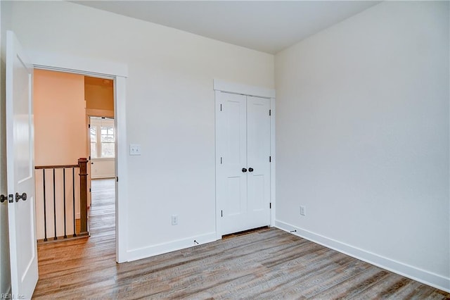 unfurnished bedroom featuring baseboards and wood finished floors
