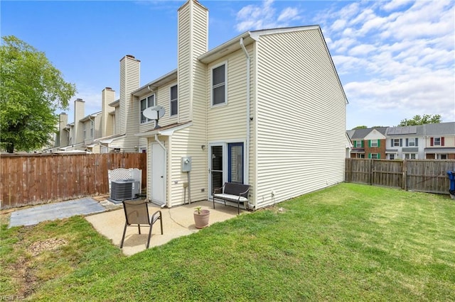 rear view of house with a chimney, a patio area, central air condition unit, and a residential view