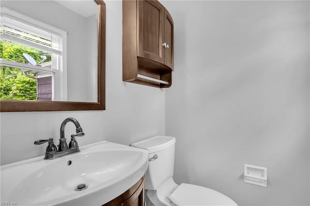 half bath featuring vanity and toilet