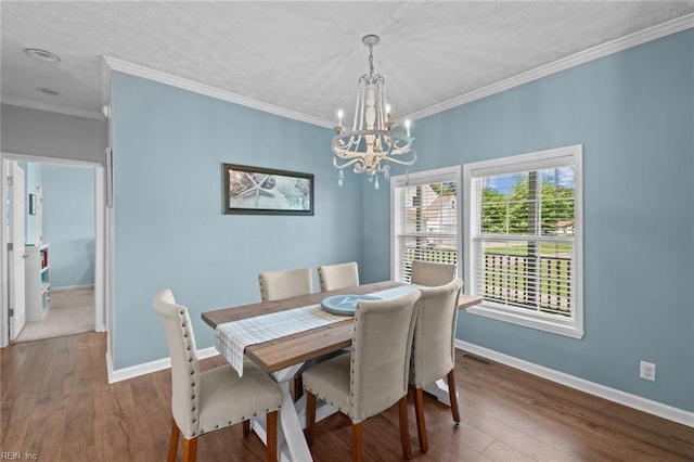 108 Hodges Cove Rd, Yorktown, VA 23692 - dining space with a textured ceiling, a chandelier, ornamental molding, baseboards, and dark wood-style flooring