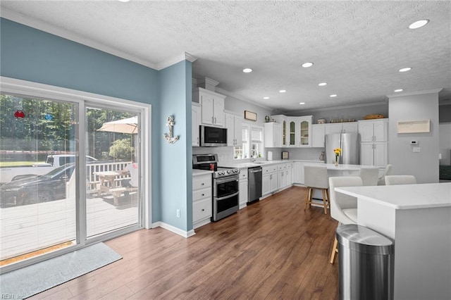 108 Hodges Cove Rd, Yorktown, VA 23692 - kitchen featuring appliances with stainless steel finishes, ornamental molding, a textured ceiling, a breakfast bar, and light countertops
