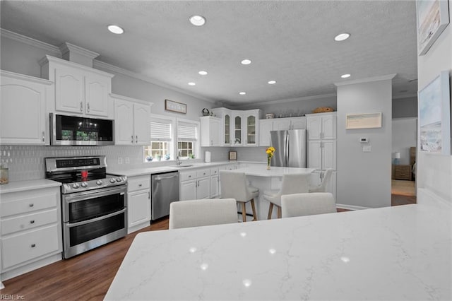 108 Hodges Cove Rd, Yorktown, VA 23692 - kitchen with stainless steel appliances, ornamental molding, recessed lighting, dark wood-type flooring, and white cabinetry