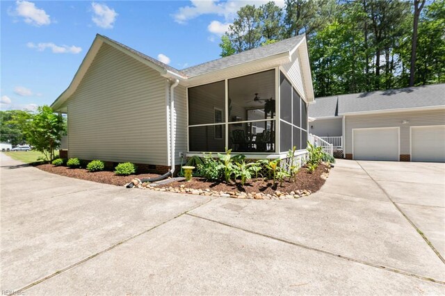 108 Hodges Cove Rd, Yorktown, VA 23692 - view of side of home with driveway, a sunroom, an attached garage, and a ceiling fan