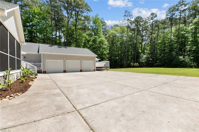 108 Hodges Cove Rd, Yorktown, VA 23692 - view of side of property featuring an attached garage, concrete driveway, a lawn, and a sunroom