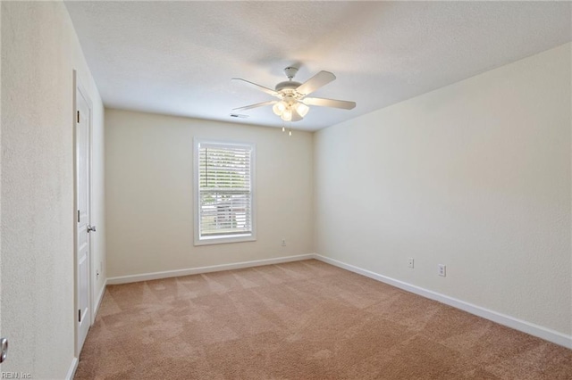 unfurnished room featuring baseboards, visible vents, ceiling fan, and light colored carpet