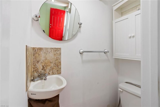 half bathroom featuring toilet and a sink