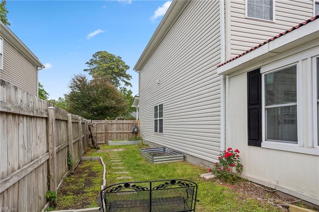 view of yard with a fenced backyard and a vegetable garden