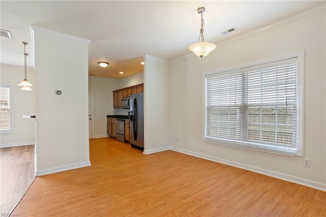 interior space with crown molding, baseboards, visible vents, and light wood-style floors