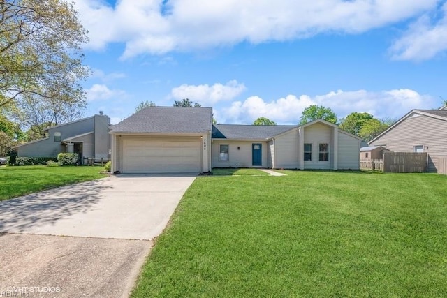view of front of home with concrete driveway, an attached garage, a front lawn, and fence