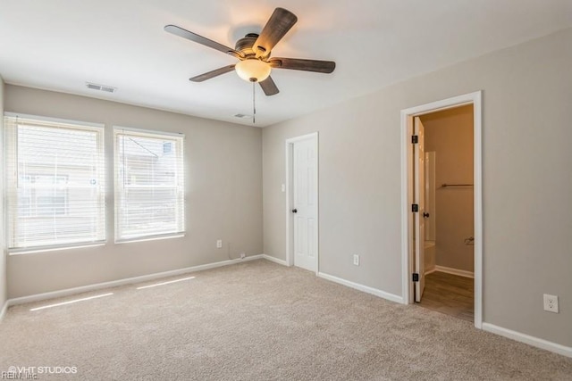unfurnished bedroom with carpet flooring, connected bathroom, visible vents, and baseboards