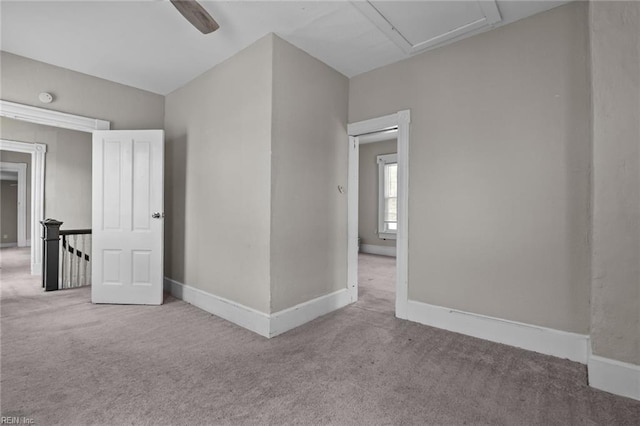 carpeted empty room featuring baseboards and a smoke detector