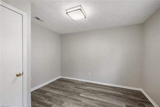 spare room with wood finished floors and baseboards