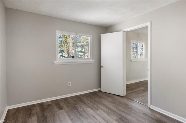 unfurnished bedroom featuring wood finished floors and baseboards