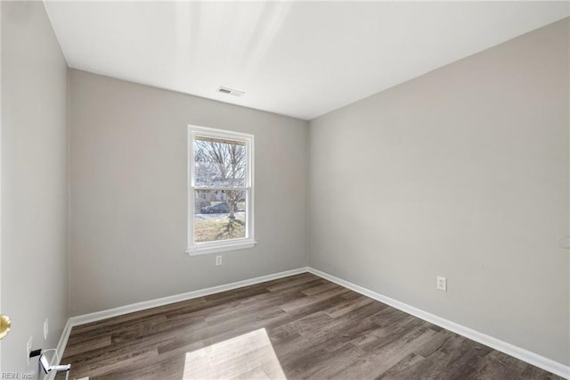 empty room featuring wood finished floors and baseboards