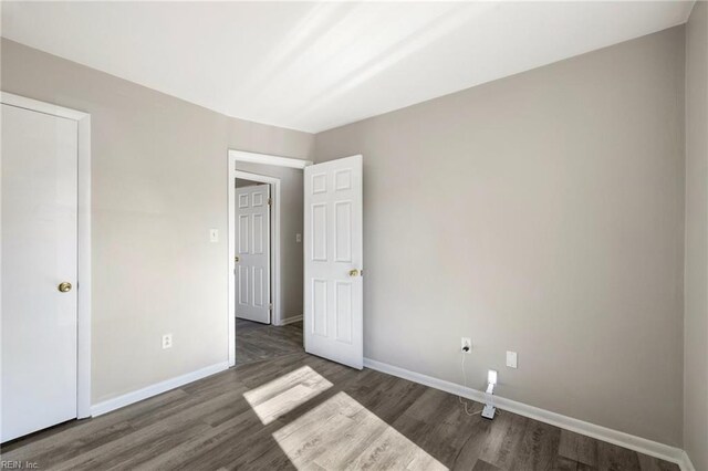 unfurnished bedroom featuring wood finished floors and baseboards