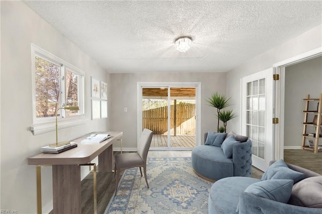 office space featuring wood finished floors, baseboards, and a textured ceiling