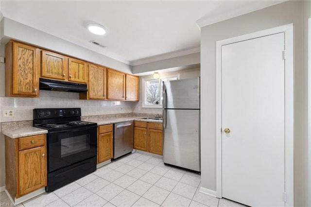 kitchen featuring appliances with stainless steel finishes, under cabinet range hood, light countertops, brown cabinetry, and crown molding