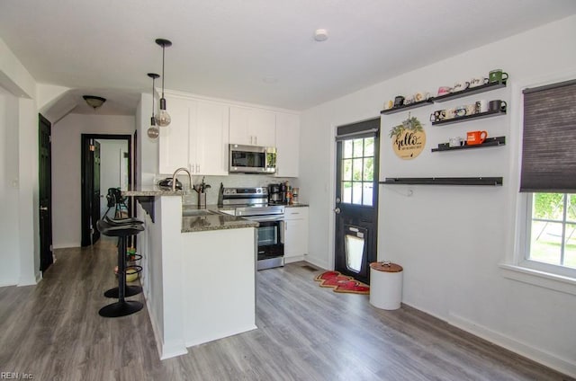 8123 Kenwood Dr, Norfolk, VA 23518 - kitchen featuring stainless steel appliances, a sink, a breakfast bar, and white cabinets