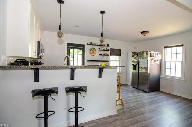 8123 Kenwood Dr, Norfolk, VA 23518 - kitchen with stainless steel appliances, white cabinetry, a peninsula, wood finished floors, and a kitchen bar