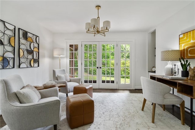 sitting room featuring wood finished floors, french doors, and a notable chandelier