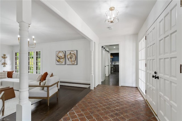 entrance foyer featuring a chandelier, baseboards, baseboard heating, and stone finish flooring