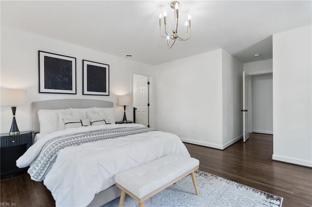 bedroom featuring baseboards, a chandelier, and wood finished floors